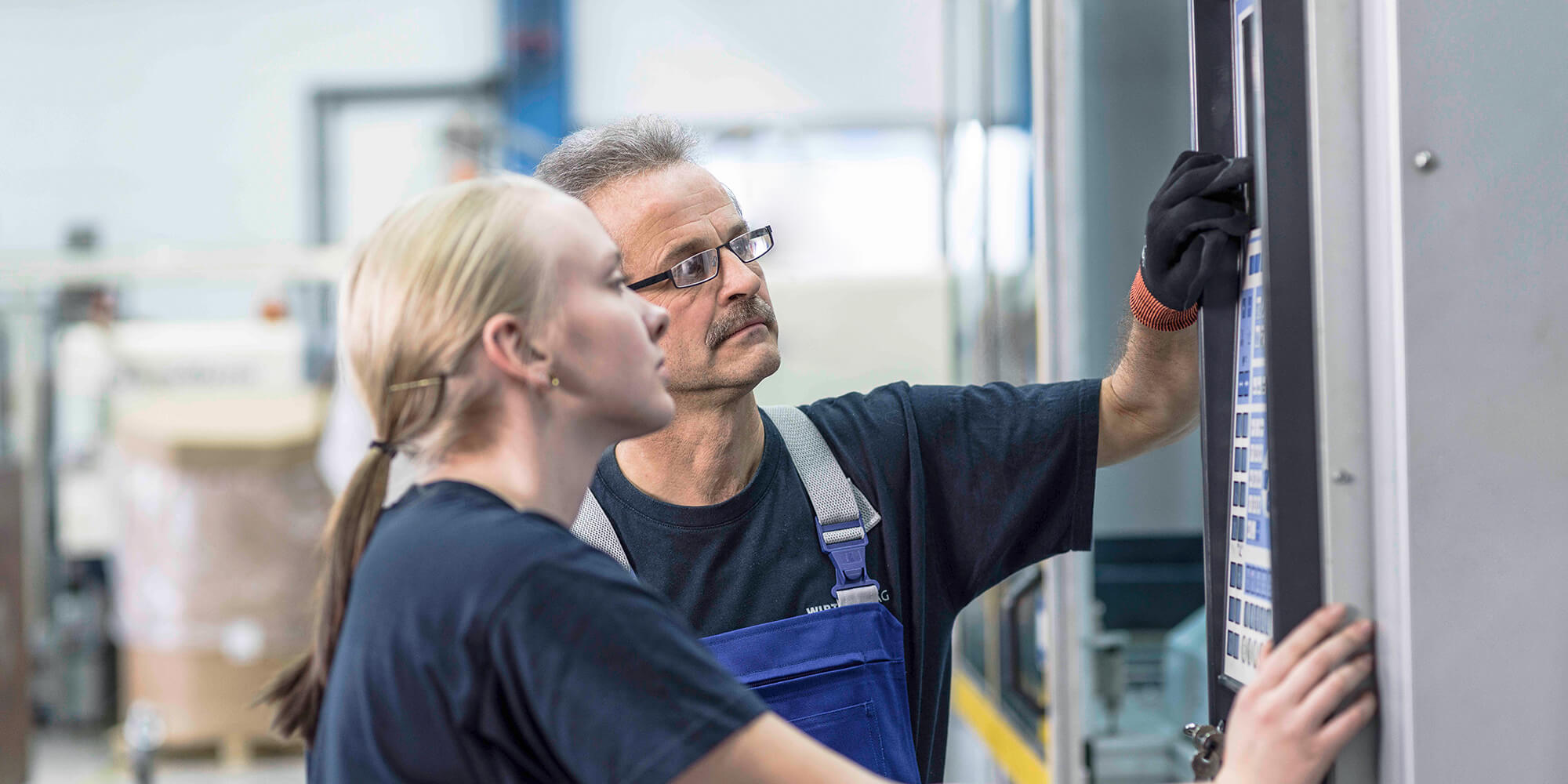2 Arbeiter stellen Spritzgießmaschine ein  
